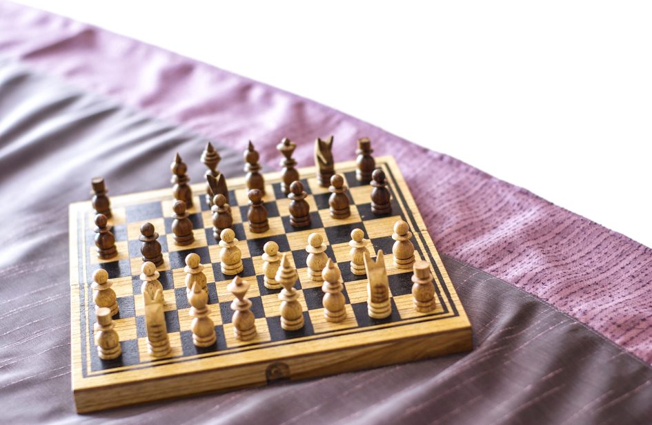 Chess on bed in hotel room